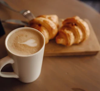 cappuccino-with-beautiful-latte-art-and-croissant-on-wooden-background